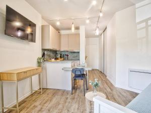 une cuisine avec des armoires blanches et une table et des chaises dans l'établissement Studio moderne proche plage avec WiFi à Dives-sur-Mer - FR-1-788-84, à Dives-sur-Mer