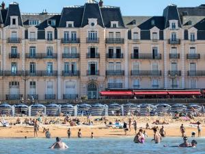 un groupe de personnes sur la plage devant un bâtiment dans l'établissement Studio moderne proche plage avec WiFi à Dives-sur-Mer - FR-1-788-84, à Dives-sur-Mer 6 autres photos
