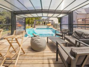 a patio with a pool and chairs and a house at Gîte en Brière avec jardin et terrasse - FR-1-306-1312 in La Chapelle-des-Marais