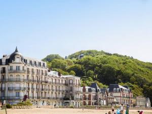 - un bâtiment sur la plage à côté d'une montagne dans l'établissement Studio moderne proche plage avec WiFi à Dives-sur-Mer - FR-1-788-84, à Dives-sur-Mer
