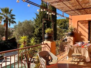 eine Terrasse mit Tisch und Stühlen auf einem Balkon in der Unterkunft Villa spacieuse à Carqueiranne pour 10 pers, proche mer - FR-1-599-120 in Carqueiranne