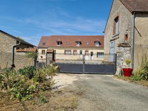 a gate in front of a building with a house at Deux gîtes charmants près d'Orléans avec jardin et parking privatif - FR-1-590-577 