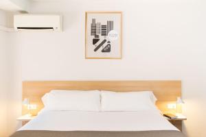 a hotel room with a white bed and white walls at Rooms Ciencias in Valencia