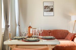 a dining room table with wine glasses and a couch at Suite design - 3 min Palais & Croisette - Central in Cannes +19 photos