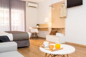 una habitación de hotel con una cama y una mesa con comida. en Rooms Ciencias, en Valencia