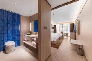 a bathroom with a bed and a sink in a room at Crystal Hotel Guangzhou Huadu in Huadu +34 photos