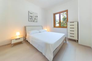 biała sypialnia z białym łóżkiem i oknem w obiekcie Villa di Lusso sul Mare a Diamante - Villa Ventre w mieście Belvedere Marittimo
