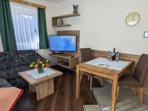 ein Wohnzimmer mit Tisch und Fernseher in der Unterkunft Landhaus Petri Heil in Seefeld in Tirol