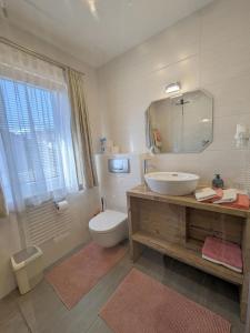 ein Badezimmer mit Waschbecken, Toilette und Spiegel in der Unterkunft Landhaus Petri Heil in Seefeld in Tirol + 13 Fotos