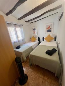 two beds in a room with white walls and windows at Tranquilo apto ideal paraTurismo Rural y Relax in Gandesa