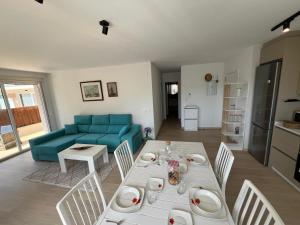 a living room with a table and a blue couch at Apartamento TURQUESA in O Porto de Espasante