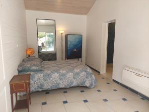 une chambre avec un lit et un miroir dans l'établissement sable gris maison d'architecte, à Andernos-les-Bains