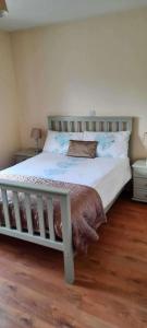 a bedroom with a large bed with a wooden floor at Tranquil Retreat at Ailt Cottage in Dunfanaghy +18 photos