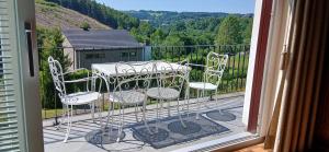 Un balcón con 2 sillas y una mesa en una terraza. en Villa des Collines, en Malmedy