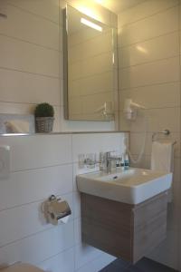 a bathroom with a sink and a mirror at Sonne Living - Wohlen in Wohlen