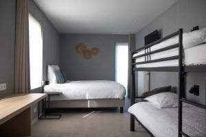 a bedroom with two bunk beds and a desk at B&B Abdeshof in Middelkerke