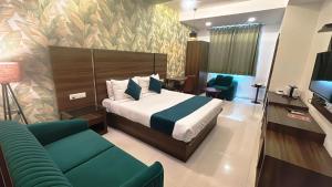 a hotel room with a bed and a couch at Hotel Green Woodd in Anand