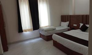 een hotelkamer met twee bedden en twee ramen bij FabHotel Shaurya Inn I - 400m from Golden temple in Amritsar +16 foto's