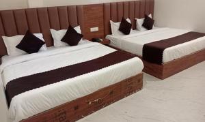 twee bedden in een hotelkamer met twee bij FabHotel Shaurya Inn I - 400m from Golden temple in Amritsar