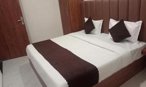 een slaapkamer met een groot bed met zwart-witte kussens bij FabHotel Shaurya Inn I - 400m from Golden temple in Amritsar