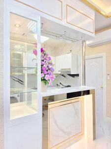 a kitchen with a counter with a vase of flowers at Marina Villa, North Pattaya in Pattaya North