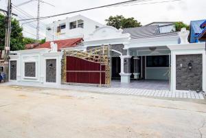 a house with a red gate in a street at Marina Villa, North Pattaya in Pattaya North