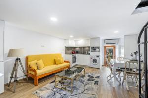 a living room with a yellow couch and a table at Casa Da Ribeira in Selhariz