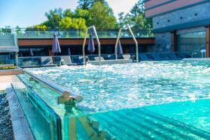 a person standing in the water in a swimming pool at Grand Hotel Bansko - Fitness & SPA in Bansko