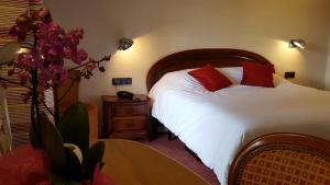 A bed or beds in a room at Hotel Restaurant Père Benoît