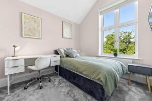 a bedroom with a bed and a desk and a window at Modern 3BR Home in 24 Breeden Dr Near M6, NEC & Airport Hot Tub, Netflix, Free Parking in Curdworth