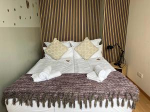 a bed with white towels and pillows on it at COOLEST Apartment in Berlin, easy Check-in, near BER Airport - Quiet&Cozy Penthouse in Schönefeld