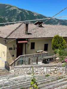 a house with a stone fence in front of it at Casa Vacanze DaMa in Frattura
