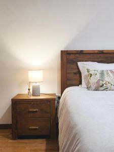 Un dormitorio con una cama y una mesita de noche con una lámpara. en Villarmo cais, en Viana do Castelo
