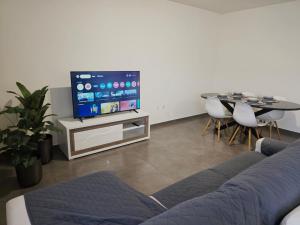 Una sala de estar con un sofá, un televisor y una mesa. en Villarmo cais, en Viana do Castelo