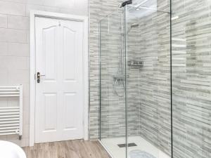 a bathroom with a shower with a glass door at 2 Bed in Moelfre 75013 in Moelfre +20 photos