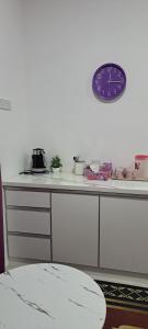 una encimera de cocina con reloj en la pared en Teratak Sumayyah - For Islam Only - Pondok Lenggong, en Kampong Banggol Belimbing