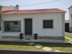 a white house with two plants in front of it at Casa Sabela in Tomiño