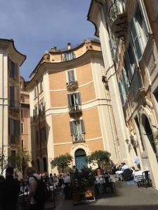 a building with people sitting at tables in front of it at Vicolo Doria Apartment in Rome