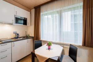 a small kitchen and dining room with a table and chairs at Alpenhof M&E in Bad Kleinkirchheim