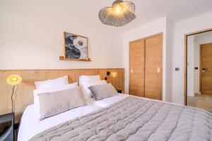 a bedroom with a large white bed in a room at TERRESENS - Les Sources de Canopée in Saint-Gervais-les-Bains