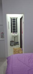 a bedroom with a purple bed and a sink at Roomstay Sumayyah - For Islam Only - Pondok Lenggong in Kampong Banggol Belimbing +9 photos