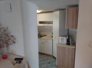 a small kitchen with white cabinets and a counter at Holiday Home Vucina in Sveti Juraj