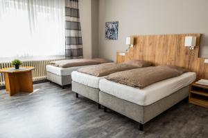 a bedroom with two beds and a window at Landhotel Georgshof in Hünfeld
