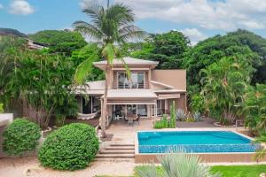 une maison avec une piscine devant dans l'établissement Casa Amani, à Tamarindo