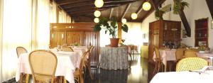 ein Esszimmer mit Tischen und Stühlen mit weißem Tischtuch in der Unterkunft Hotel Cella in Arta Terme