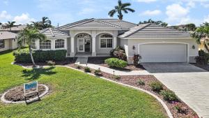 a house with a garage in a yard at Boaters Dream S. Terr Pool Yacht Club Boating in Cape Coral
