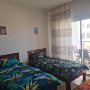 a bedroom with two beds and a window at Diar el bahar zarzis sonia marina in Zarzis