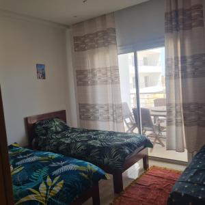 a room with two beds and a balcony with a table at Diar el bahar zarzis sonia marina in Zarzis +13 photos