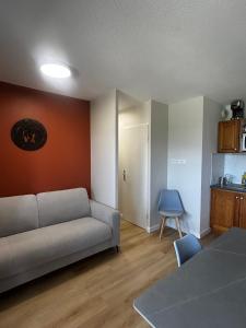 a living room with a couch and a kitchen at Appartement T2 Superdévoluy - Les Chaumettes in Le Dévoluy
