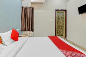 a bedroom with a large bed with red and white pillows at RROOMS Hotel Orphic Inn in Lucknow